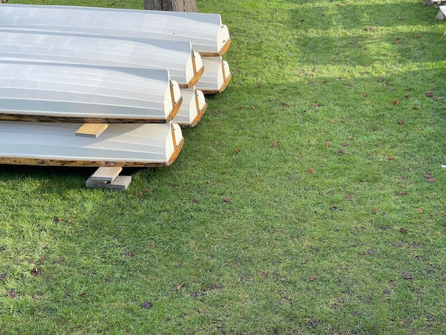 Plan recadré de bateaux en bois blancs stockés sur l'herbe verte