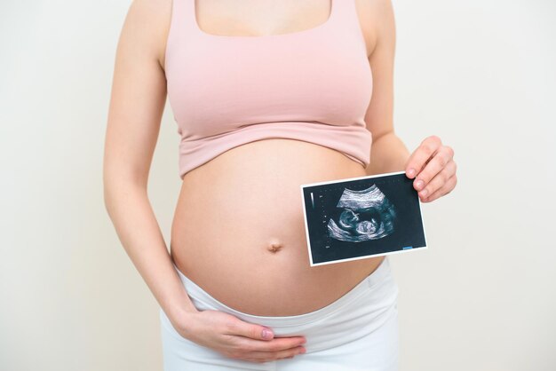 une photo recadrée d'une femme enceinte après une échographie