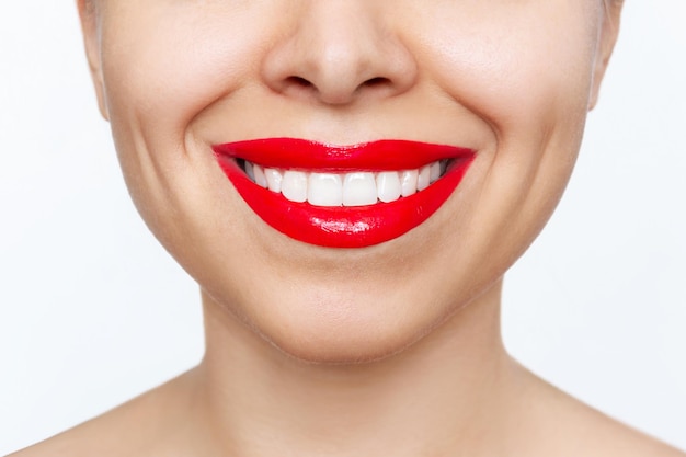 Plan recadré d'une jeune femme souriante avec des dents parfaites et uniformes isolées sur fond blanc