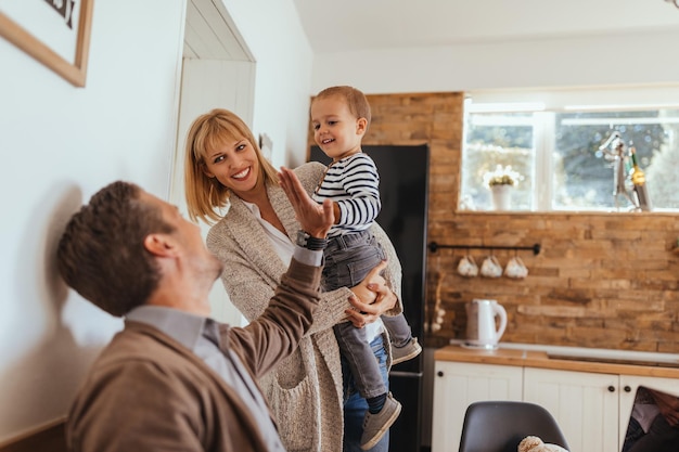 Plan recadré de jeunes parents avec son fils profitant de la cuisine