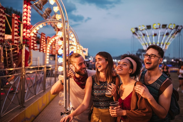 Plan recadré de quatre amis dans un parc d'attractions