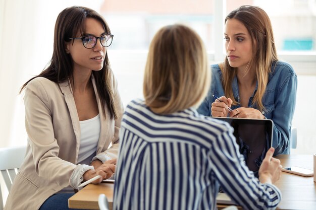 Plan de trois collègues de travail travaillant ensemble dans un espace de travail moderne. Concept de remue-méninges.