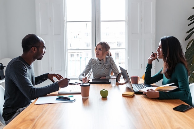 Plan de trois collègues de travail travaillant ensemble dans un espace de travail moderne. Concept de remue-méninges.