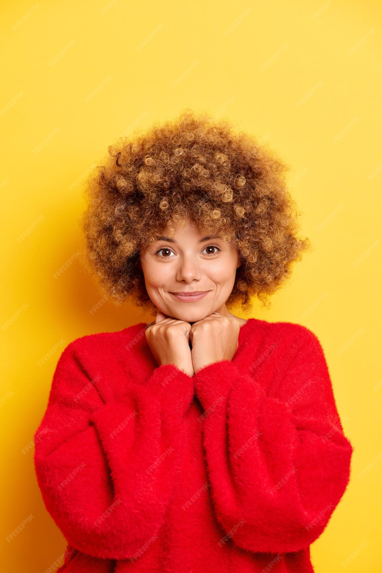 Plan vertical d'une jolie jeune femme aux cheveux bruns bouclés garde