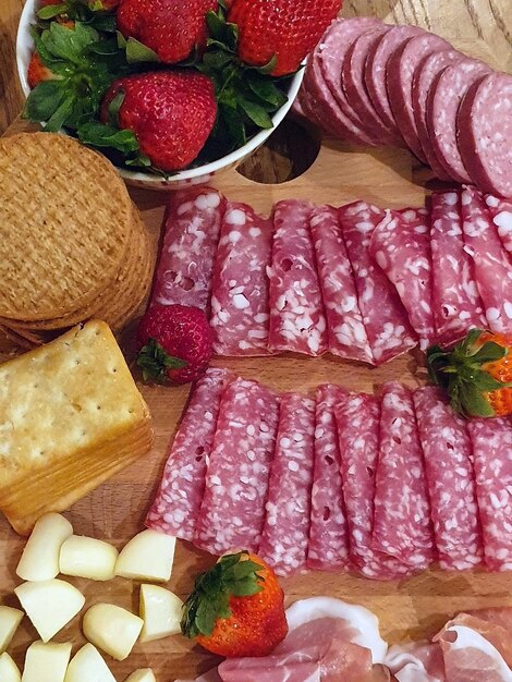 Plan vertical d'une planche de charcuterie avec de délicieuses collations sous la lumière