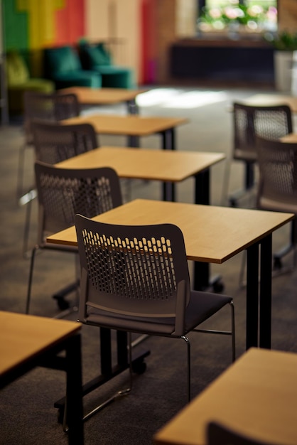 Plan vertical d'une salle de classe ou de conférence vide avec des bureaux et des chaises mise au point sélective