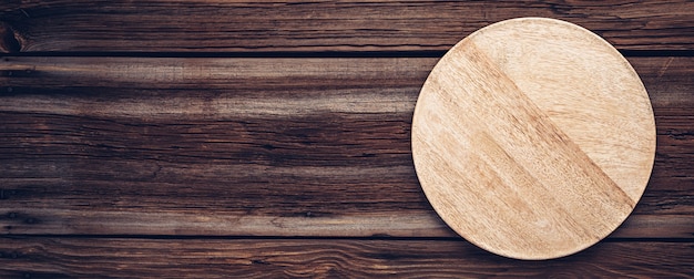 Planche ou assiette à pizza en bois pour la nourriture sur de vieilles planches en bois