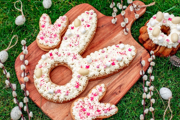 Une planche en bois avec des biscuits de Pâques en forme de lapin dessus