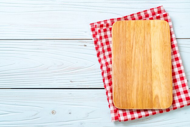 Planche de bois coupe vide avec un torchon de cuisine sur fond en bois bleu, vue de dessus