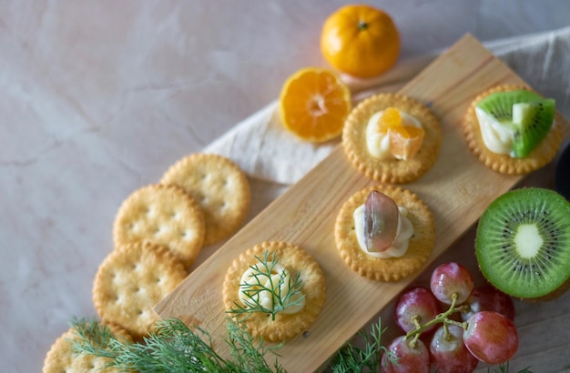 Photo une planche de bois avec des craquelins et des raisins dessus