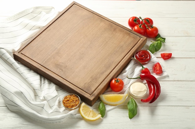 Planche de bois différentes sauces et légumes sur table