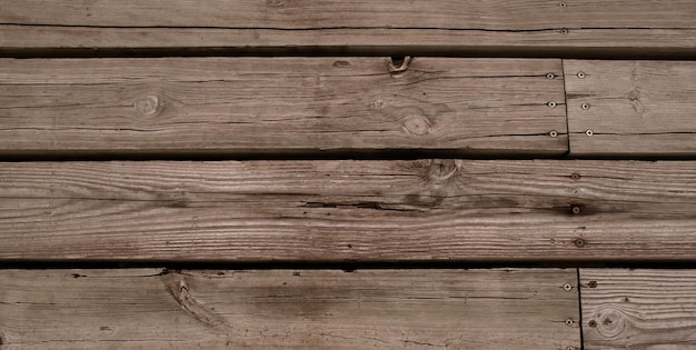 Une planche de bois avec un nœud au milieu qui a un trou.