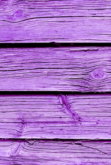 Planche de bois patiné peint sur fond violet proton