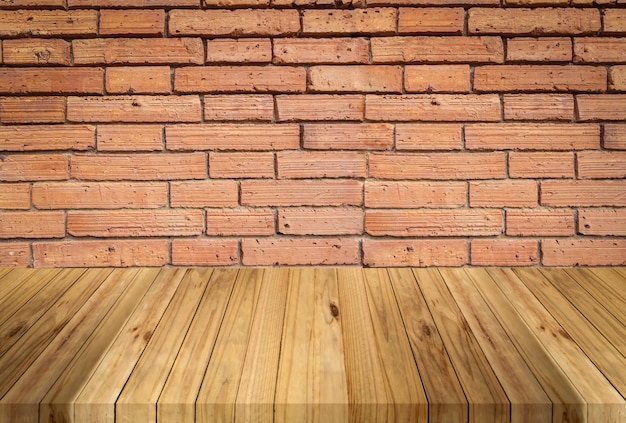 Photo planche de bois perspective avec fond de mur de briques rouges