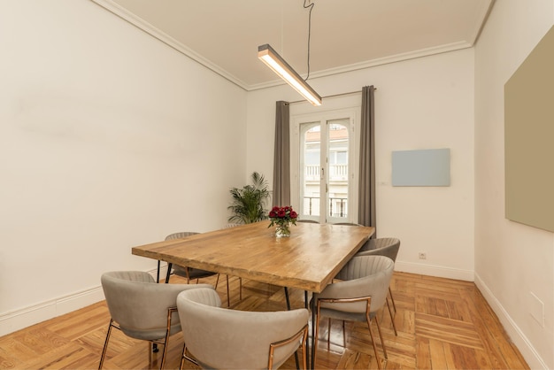 Une planche en bois avec des pieds en métal et des chaises rembourrées en velours gris