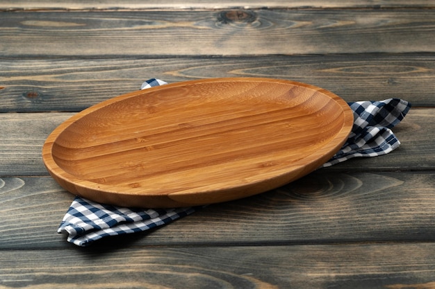 Planche de bois avec serviette de cuisine sur table en bois foncé