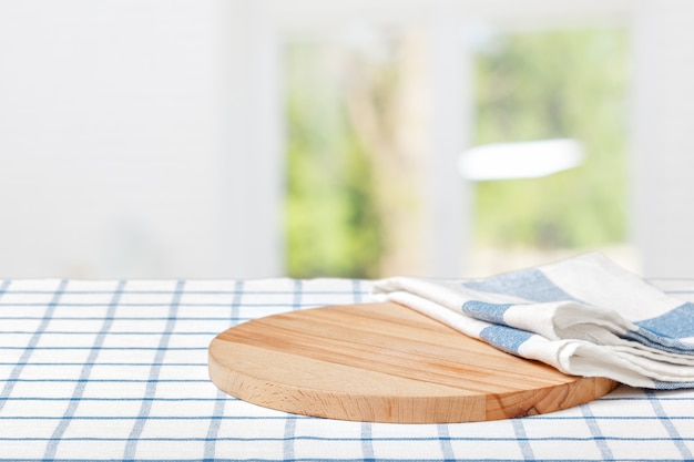 Planche de bois avec une serviette sur une table