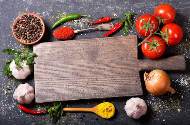 Planche de bois vide avec divers produits pour la cuisson sur fond sombre