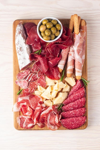 Photo planche de charcuterie apéritifs antipasti de plateau de viande et de fromage avec salami prosciutto crudo