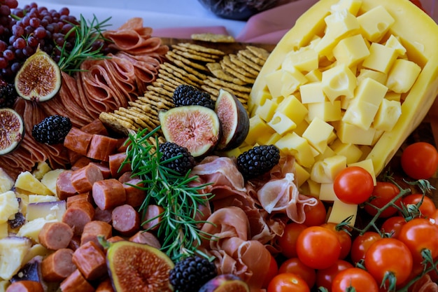 Planche de charcuterie avec assortiment de fromages, fruits et charcuterie. Fermer.