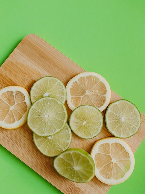 Photo une planche à couper avec des citrons et des citrons verts dessus