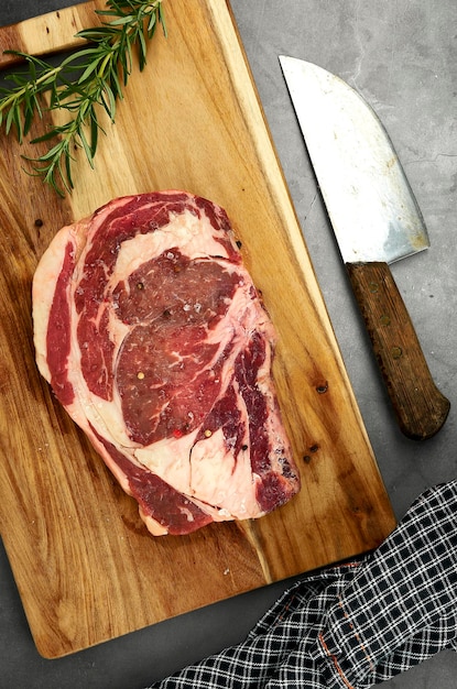 Photo une planche à couper avec un couteau et un steak dessus