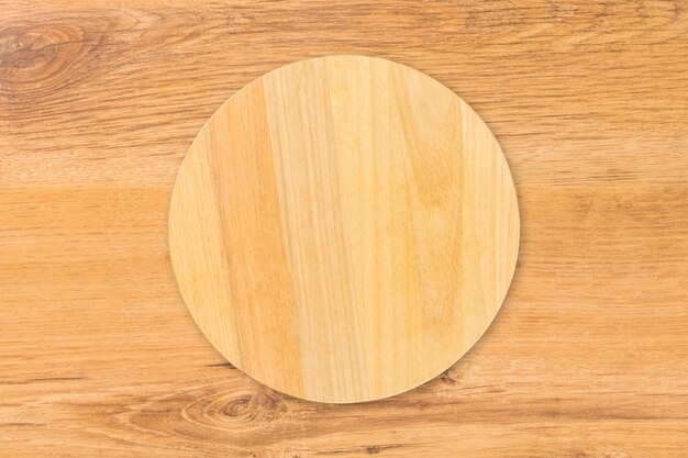 Planche de cuisine de coupe en bois circulaire, isolée sur table en bois