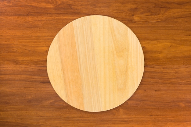 Planche de cuisine de coupe en bois circulaire, isolée sur table en bois