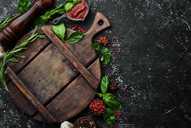 Planche de cuisine avec épices et herbes sur fond de pierre noire Vue de dessus Espace libre pour votre texte