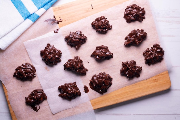 Une planche à découper en bois avec des biscuits au chocolat dessus