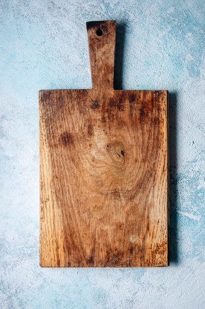 Planche à découper en bois sur fond bleu clair