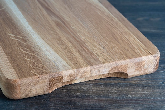 Planche à découper en bois sur fond de table en bois