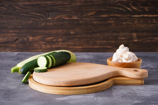 Planche à découper en bois et légumes sur table en bois, place pour le texte.