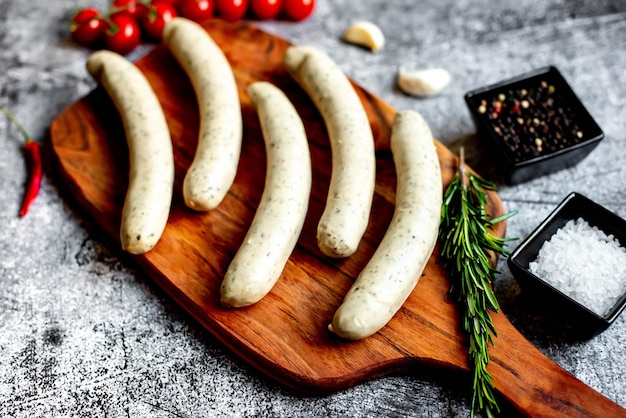 Une planche à découper en bois avec un tas de saucisses dessus.