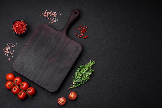 Planche à découper en bois vide avec tomates cerises épices sel et herbes