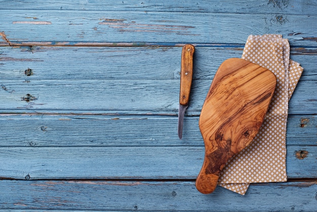 Planche à découper et couteau sur un fond en bois bleu