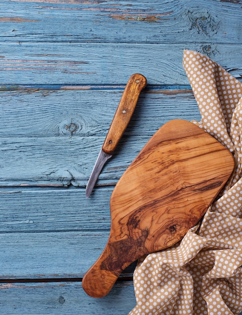 Planche à découper et couteau sur un fond en bois bleu