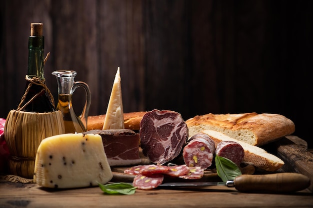 Planche à découper avec du pain au fromage jambon salami sur une planche de bois rustique close up