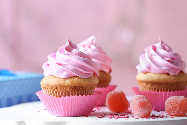 Planche avec de délicieux cupcakes et bonbons à la marmelade sur la table