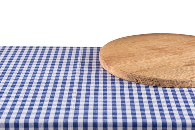 Planche de pizza en bois vide sur nappe à carreaux bleu.