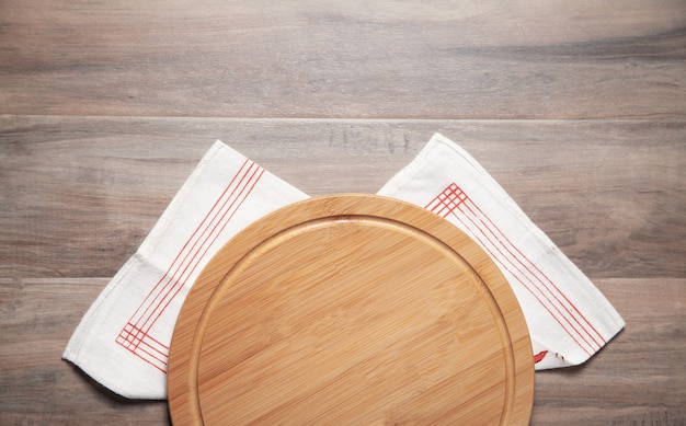 Planche à Pizza Vide Et Nappe En Tissu Sur Le Fond En Bois.