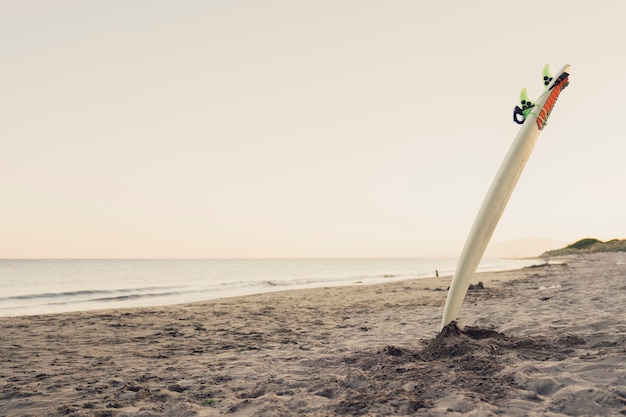 Photo planche de surf collant dans le sable