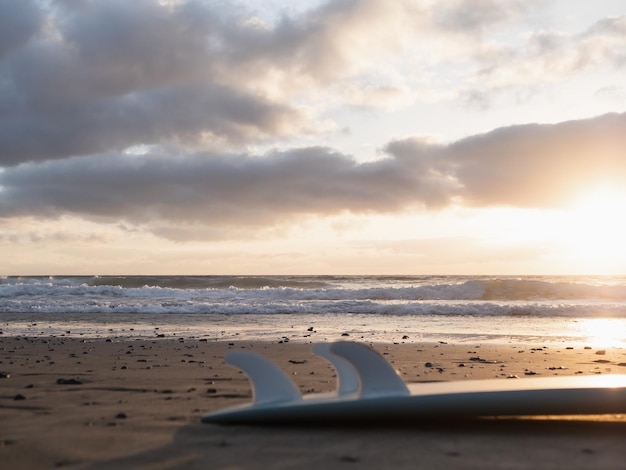 Planche de surf sur la plage au lever du soleil