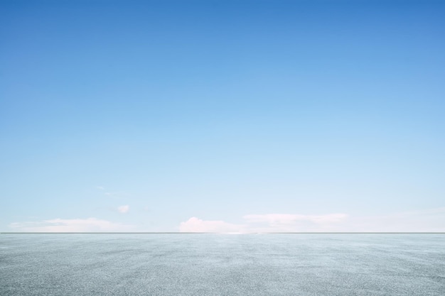 Plancher d'asphalte vide avec ciel bleu clair.