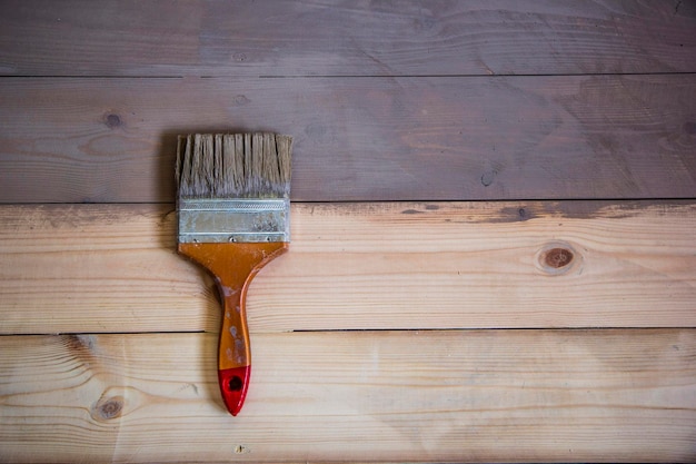 Plancher en bois peint de couleur grise et une brosse sur le sol