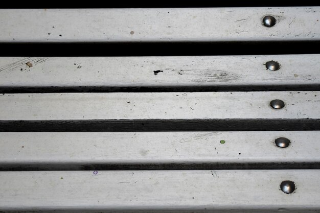 Des planches de bois blanches d'un banc de parc