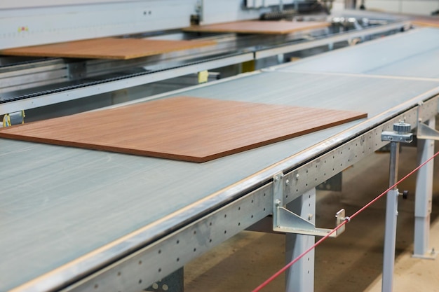 planches en bois sur convoyeur dans une usine de meubles
