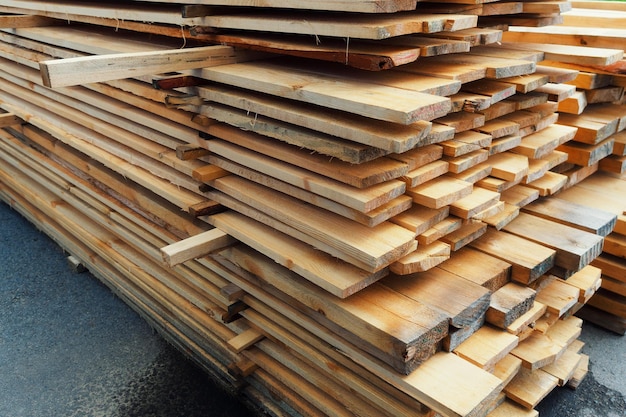 Des planches de bois sont empilées dans une scierie ou un atelier de menuiserie Séchage et commercialisation du bois