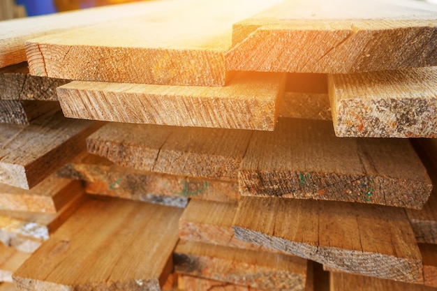 Des planches de bois sont empilées dans une scierie ou un atelier de menuiserie Séchage et commercialisation du bois