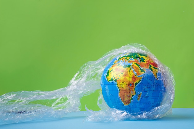 Photo planète terre dans un plastique, concept eco no plastic, globe en plastique.